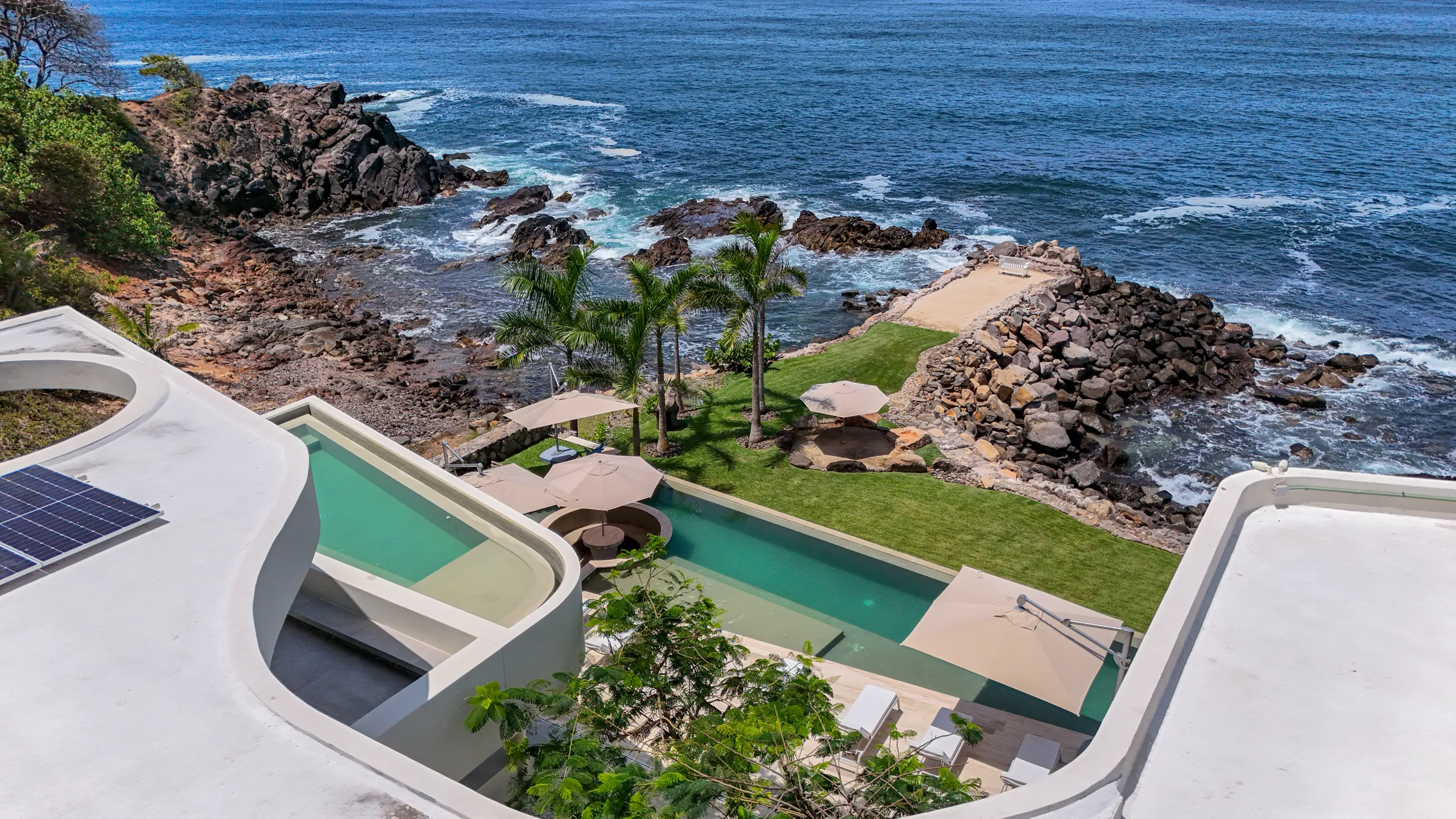 An elevated perspective showcasing the property’s direct relationship with the coastline and its exceptional oceanfront positioning.