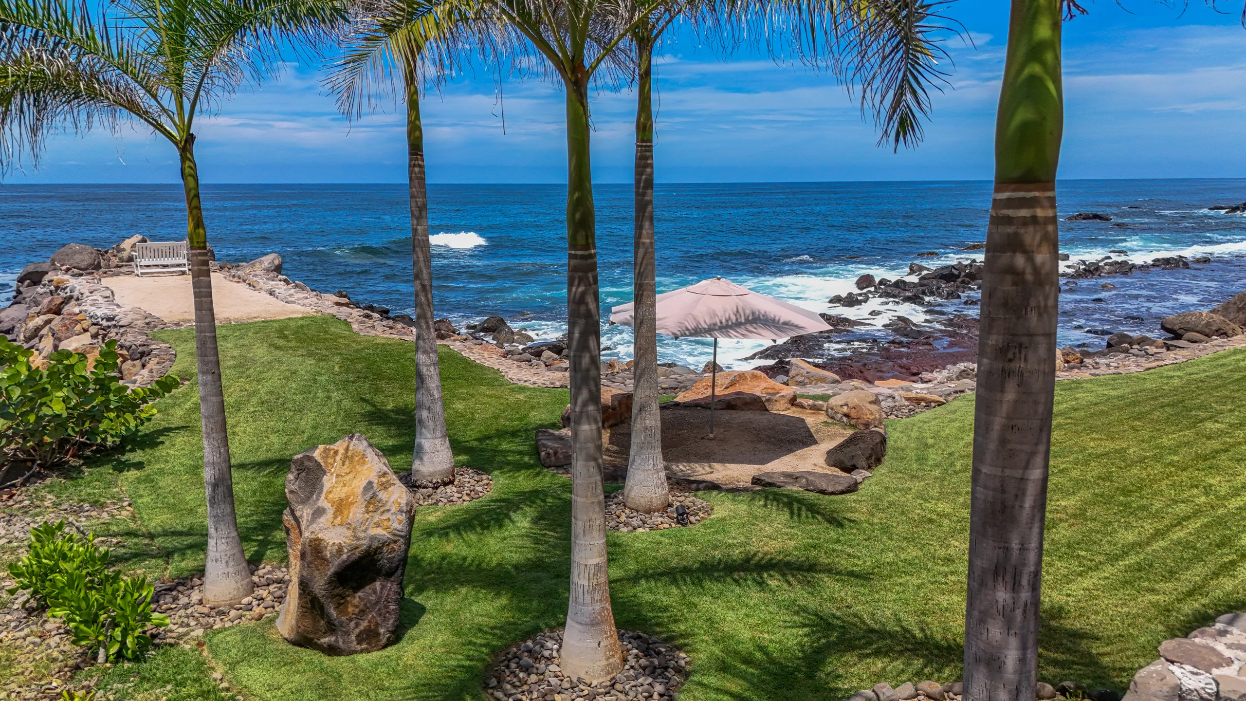 Private landscaped grounds extending toward the Pacific coastline, designed to create a calm and secluded outdoor environment.