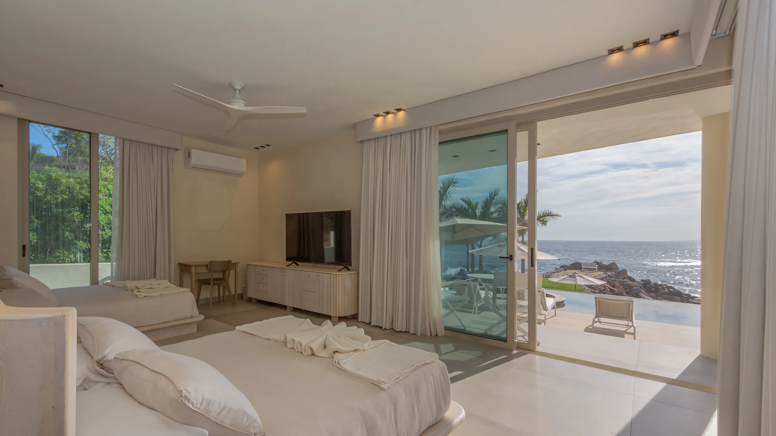 Private bedroom suite with direct terrace access and uninterrupted views toward the Pacific coastline.