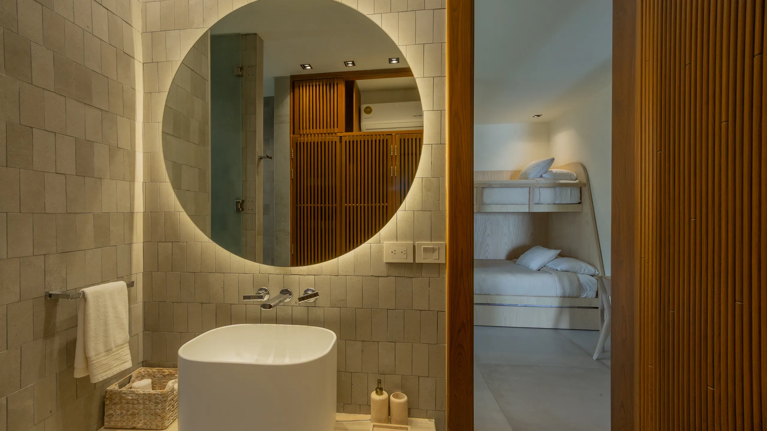 Refined bathroom details combining warm wood finishes, textured surfaces, and soft architectural lighting.