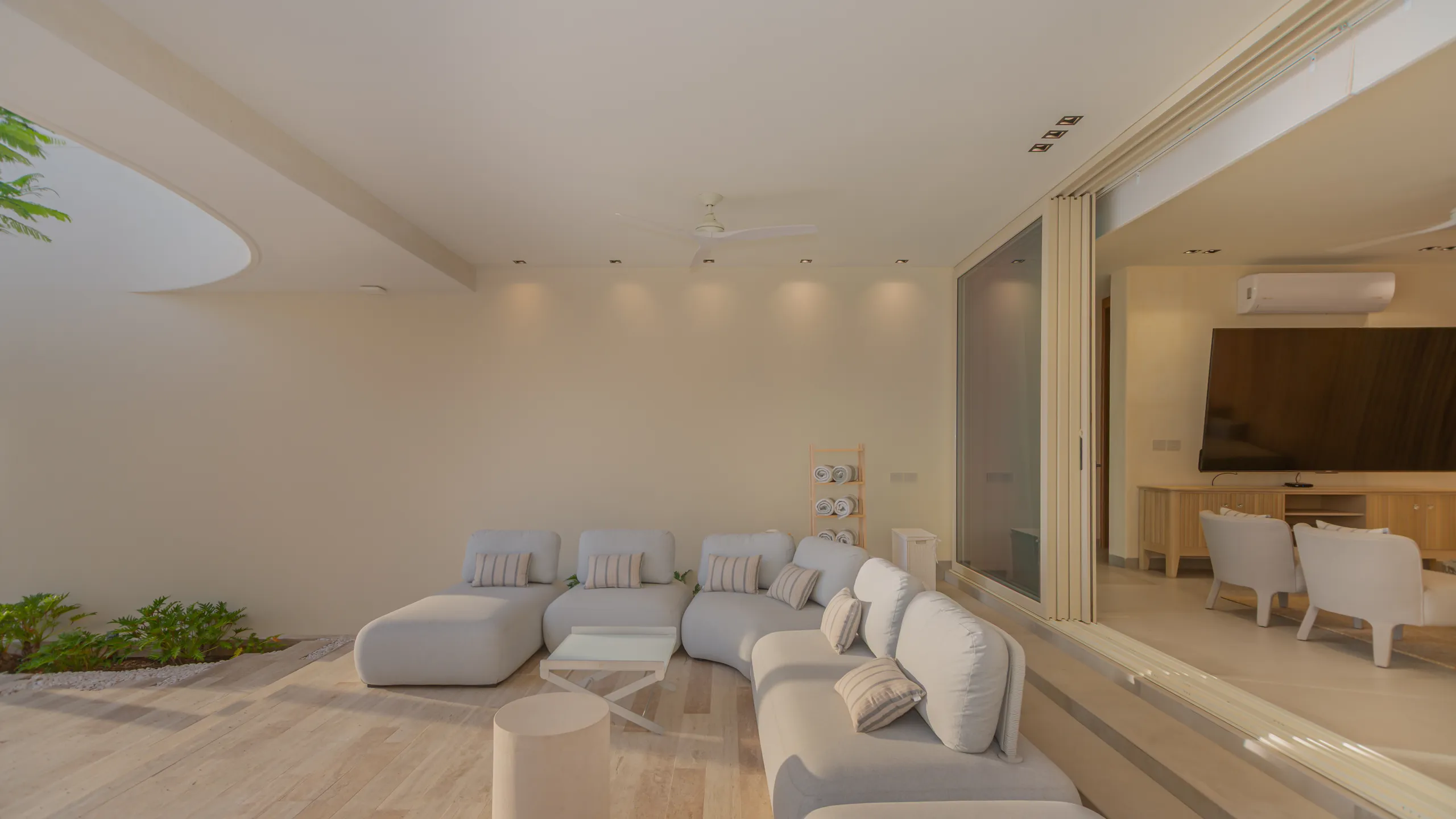 Covered outdoor lounge seamlessly connected to the interior living spaces, designed for year-round oceanfront entertaining.